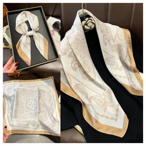Gedetailleerde collage van een vierkante sjaal van 70 cm met paisleyprint en goud.