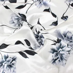 Detailed view of elegant faux silk scarf with black floral pattern on white background