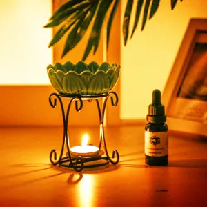 Ceramic lotus essential oil burner with metal stand, perfect for aromatherapy and home decor.