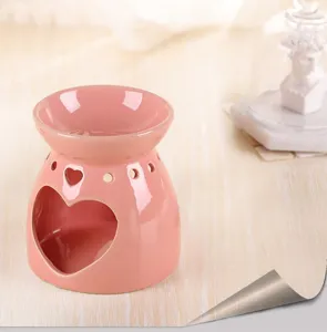 Detailansicht eines rosa herzförmigen Keramik-Aromabrenners mit glänzendem Finish