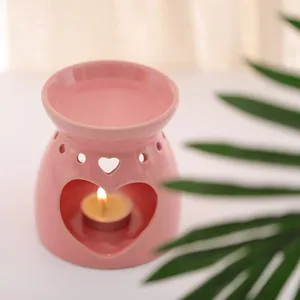 Eleganter rosa Keramik-Duftlampe mit Herzausschnitten und einem Teelicht innen.