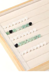 Macro detail view of heart-shaped natural crystal and agate beads on jewelry tray
