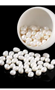 Macro detail of white natural freshwater rice pearls scattered on black surface