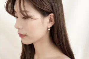 Detail shot of an elegant ginkgo leaf long drop ear line worn by an Asian model