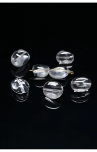 Primer plano de cuentas ovaladas de cristal blanco natural de alta claridad en negro