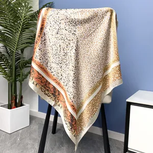 Detail view of a stylish leopard print silk square scarf elegantly draped over a chair