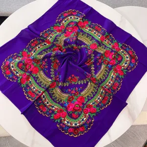 Primer plano de una bufanda étnica morada cuadrada con vivos estampados de rosas