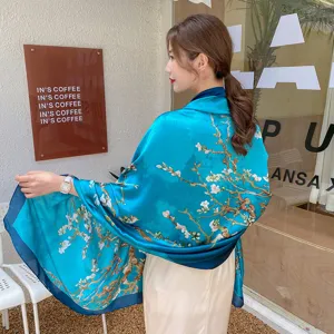 Elegante sciarpa di seta blu con stampa fiori di prugno bianco mostrata su modella