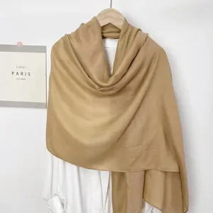 Detailaufnahme des khakifarbenen Baumwoll-Leinen-Schals auf einem weißen Hemd