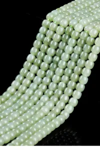 Macro view of translucent pale green HeTian jade beads arranged in a cascading strand
