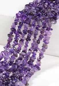 Primo piano di fili di pietre di ametista naturale viola per creazione di gioielli