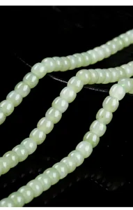 Exquisite macro close-up of natural light green Hotan jade old-style barrel beads