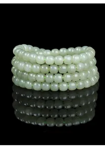 Close-up detail of natural Hetian jade barrel beads with smooth polished finish