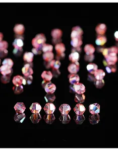 Makroaufnahme von rosa schimmernden 4mm Glasperlen auf reflektierendem Hintergrund.