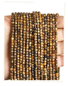 Close-up of natural yellow tiger eye stone faceted square beads for DIY jewelry making.
