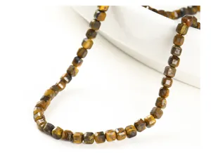 Close-up view of faceted natural yellow tiger eye sugar cube beads for DIY jewelry making