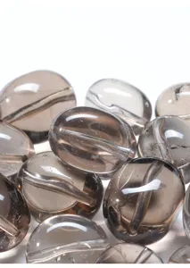 Detalle macro de cuentas ovaladas planas de cuarzo ahumado natural para joyería DIY