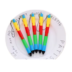 Close-up of five colorful foldable ballpoint pens with hanging straps on a plate.