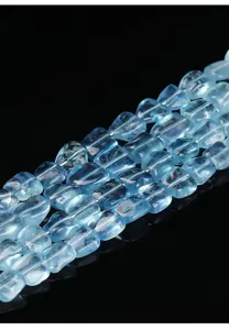 Gros plan sur des perles de pierre d'aigue-marine naturelle pour la création de bijoux