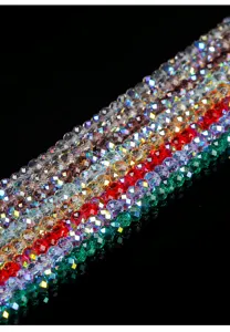 Detailed view of faceted multicolored crystal glass beads with AB coating on black background