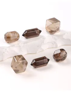 Primer plano de cuentas de cuarzo ahumado natural en formas geométricas para joyas DIY.