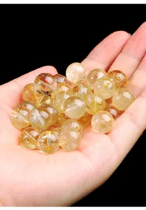 Nahaufnahme von durchscheinenden natürlichen Gold-Rutilquarz-Perlen mit Nadeleinschlüssen