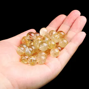Natürliche goldene Rutilquarz-Lose Perlen in der Hand für DIY-Schmuckherstellung