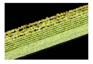 Detailed view of natural green peridot beads and crushed chips for jewelry making