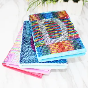 Closeup detail of colorful sequin plush notebook stack showing soft texture and bright hues.
