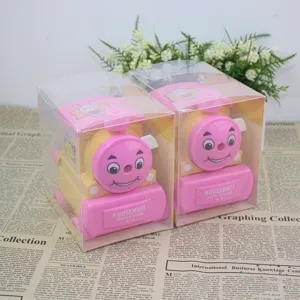 Close-up of train-shaped manual pencil sharpener in pink and yellow plastic finish