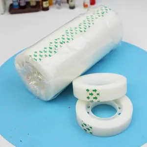Close-up detail of white invisible tape rolls with green arrow patterns on a blue background.