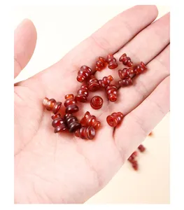 Handheld close-up of natural red carnelian agate gourd-shaped loose beads for DIY jewelry