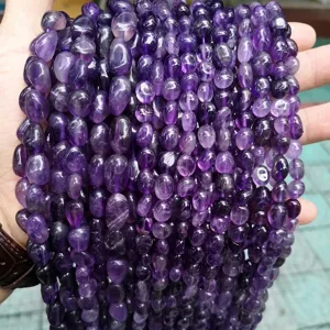 Close-up of irregular natural amethyst tumbled beads for DIY jewelry making and craft projects