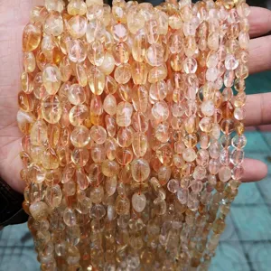 Macro detailed view of natural yellow citrine crystal irregular tumbled beads on strands