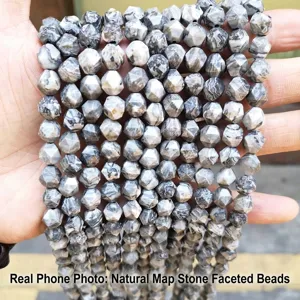 Detailed macro shot of natural map stone faceted diamond beads with grey marble texture