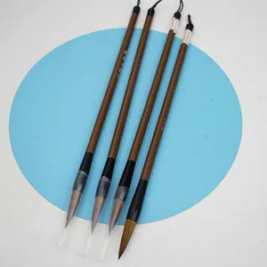 Detailed view of four Chinese calligraphy wolf hair brushes with protective caps for practice.