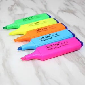 Close-up detail of five vibrant colorful fluorescent highlighter markers on marble