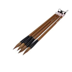 Detailed view of four Chinese calligraphy brushes with brown handles and soft bristles.