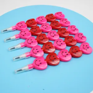 Vista dettagliata di matite impilabili a forma di cuore con faccine sorridenti rosa e rosse.