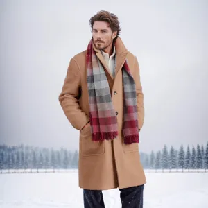 Professionelle Außenaufnahme eines Mannes in einem kamelfarbenen Wollmantel im Schnee