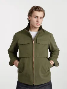 Detalle de la chaqueta utilitaria verde militar para hombre con cremallera y bolsillos.