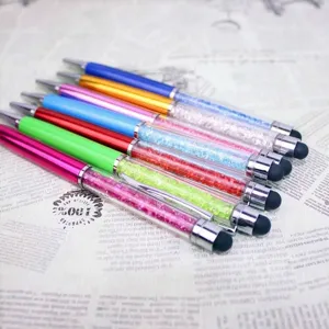 Detalle de bolígrafos táctiles con cristales de colores sobre papel vintage