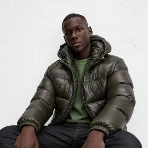 Detail shot of men's glossy dark green hooded puffer jacket featuring zip closure and cozy padding.