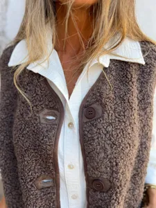 Gros plan detail de gilet en polaire sherpa marron fermeture boutons texture tissu doux.