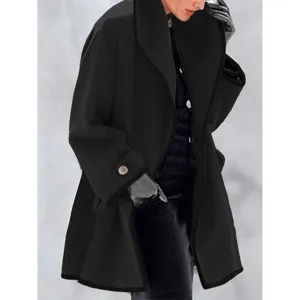 Close-up view of a black oversized wool coat with color-block edging and sleeve button