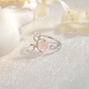 Macro detail of an antler ring featuring a pink strawberry quartz bead in soft light.