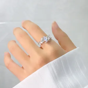 Gros plan d'une bague branche en argent avec zircone poire et détails de feuilles entrelacées.