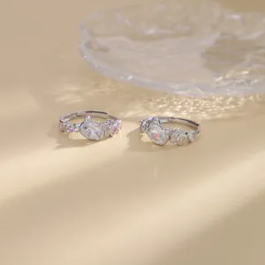 Detail shot of two silver cat-themed rings with sparkling pink and clear zircons.