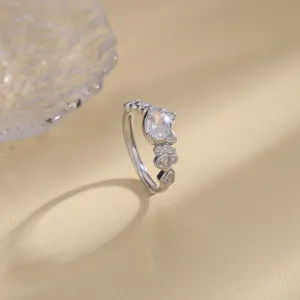 Macro view of an elegant silver cat-themed ring featuring zircon cat head and paw details.