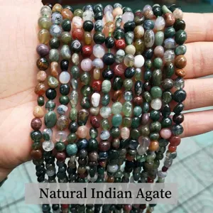 Detalle de cuentas irregulares de ágata india natural multicolor sostenidas en mano